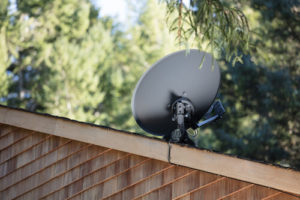 A satellite dish sits on top of a roof